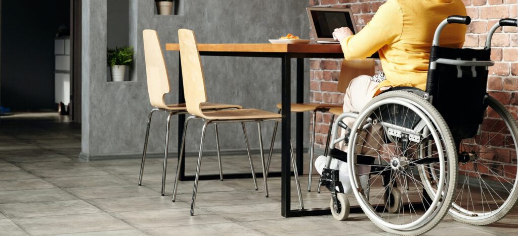 person in wheelchair at table