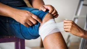 injured knee being wrapped in a bandage